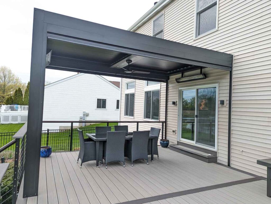 Dining area under a louvered pergola on a gray composite deck