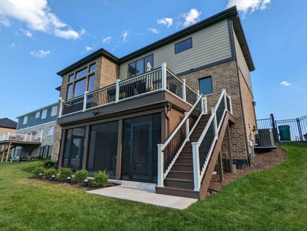 Two-level deck with white railing and a screened room beneath