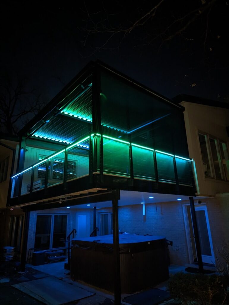 Elevated deck with a louvered roof lit at night