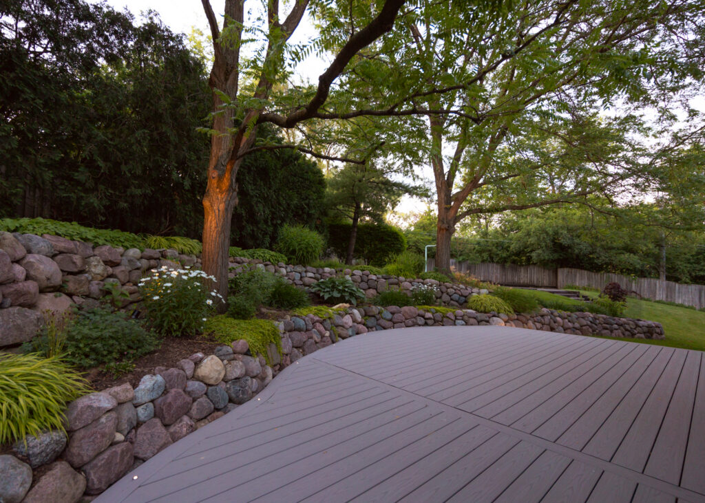 Composite deck curving along natural boulder retaining walls
