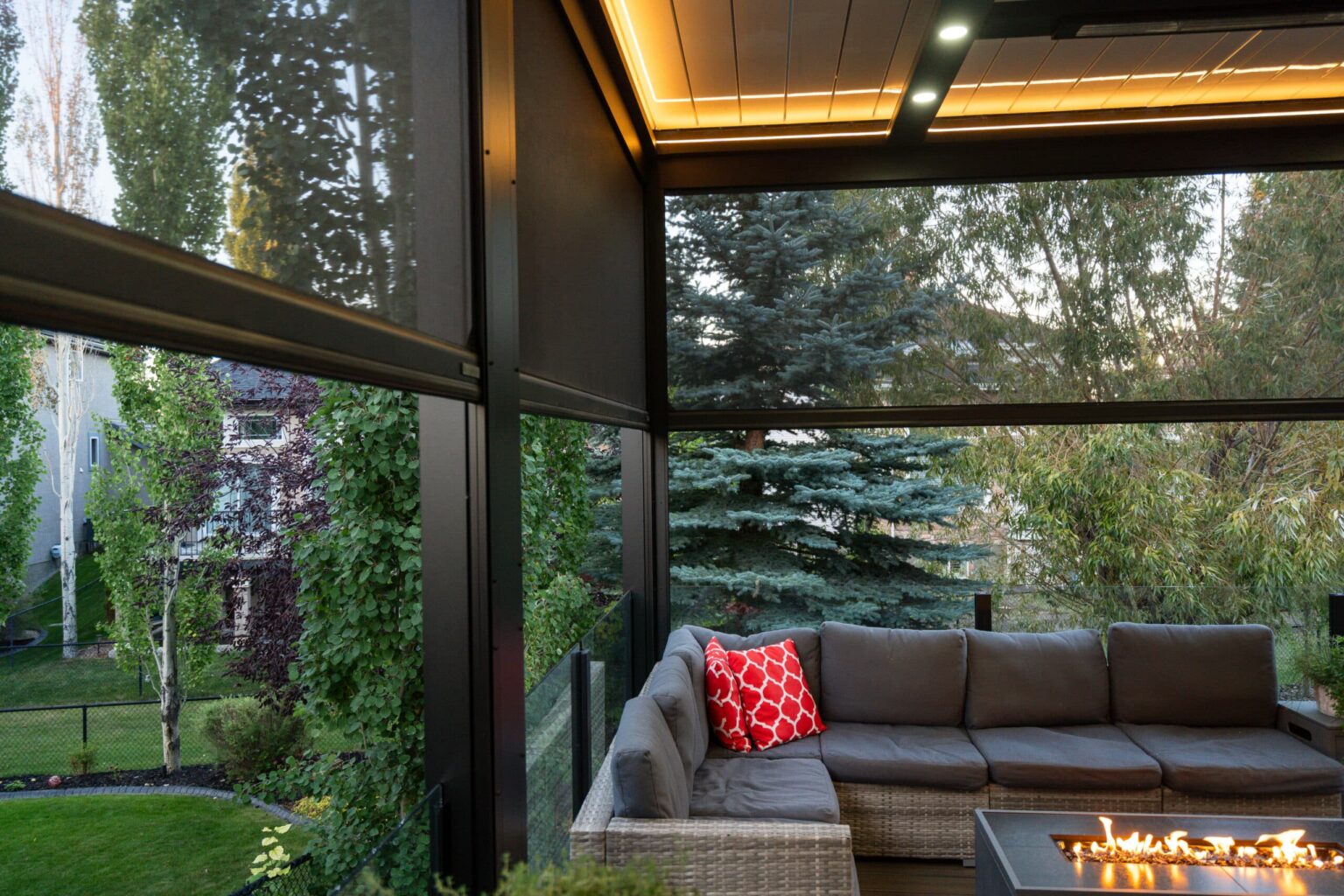 Sectional and fire table under a lit pergola