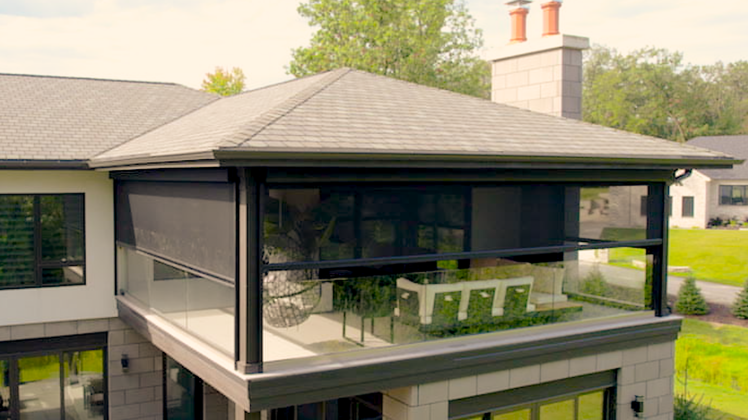 Second-story composite deck with cable railing and covered fire lounge below, built by Ace of Decks