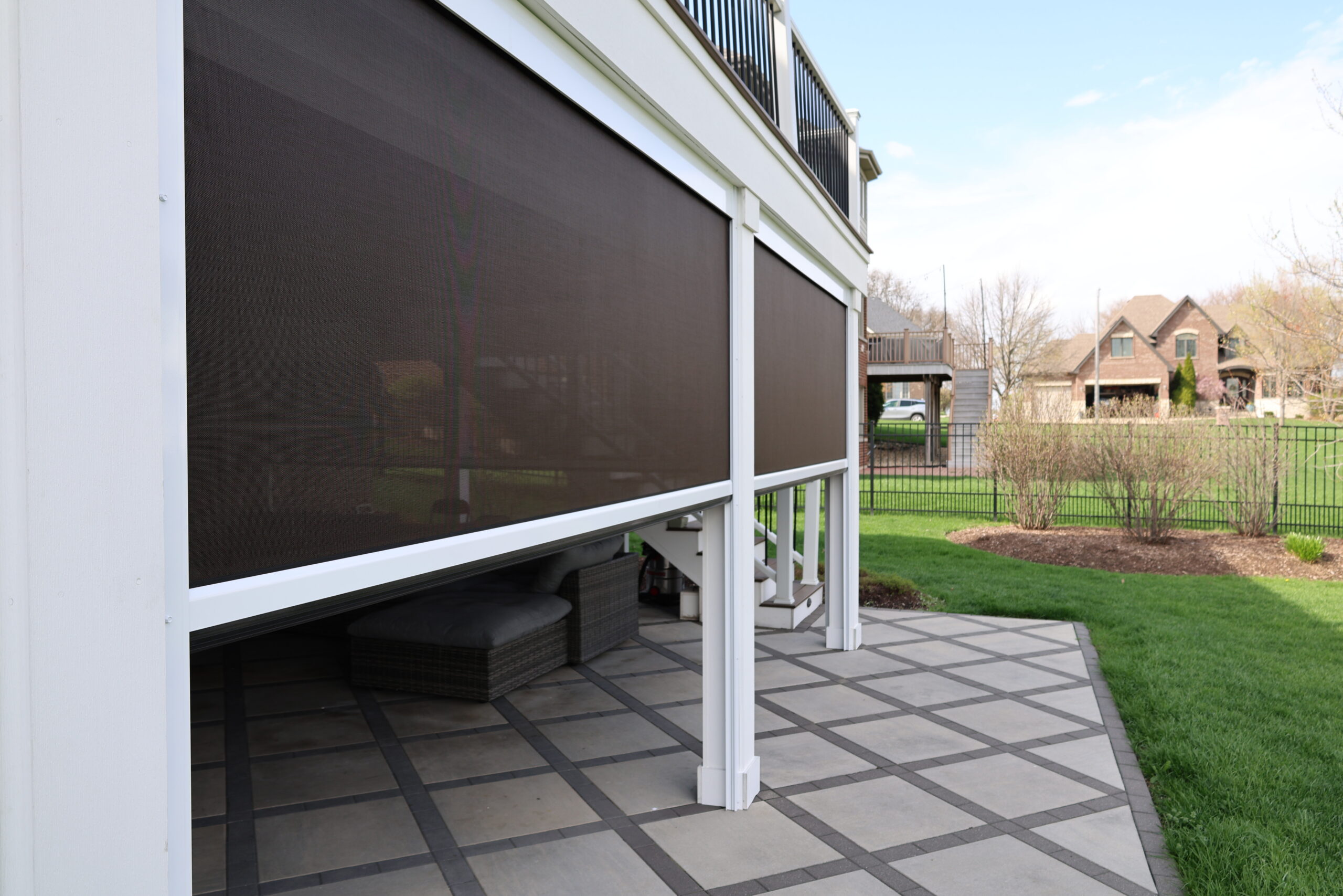 Finished lower level outdoor living space with retractable screens