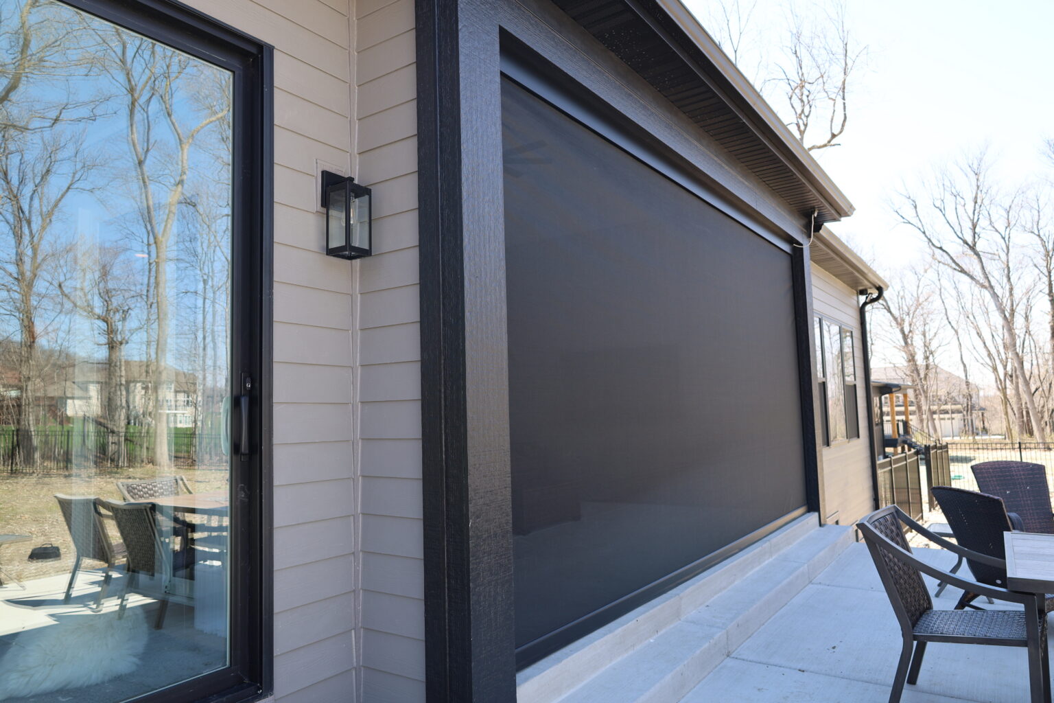 Retractable screen lowered beside patio dining chairs