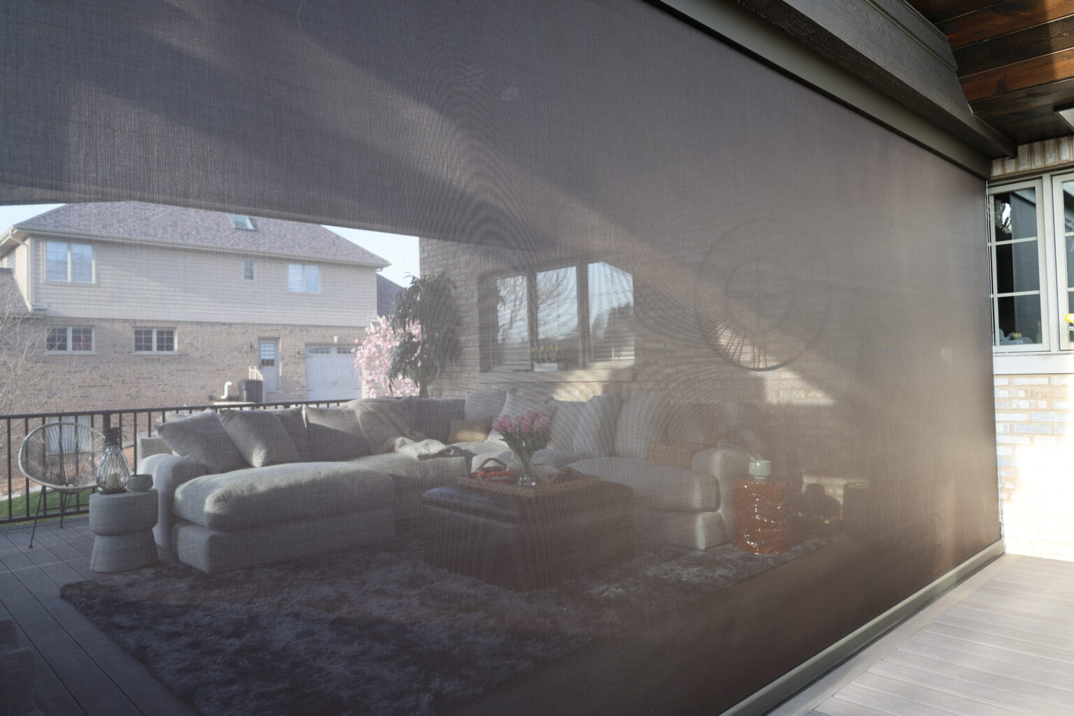 Motorized screen lowered on a covered patio