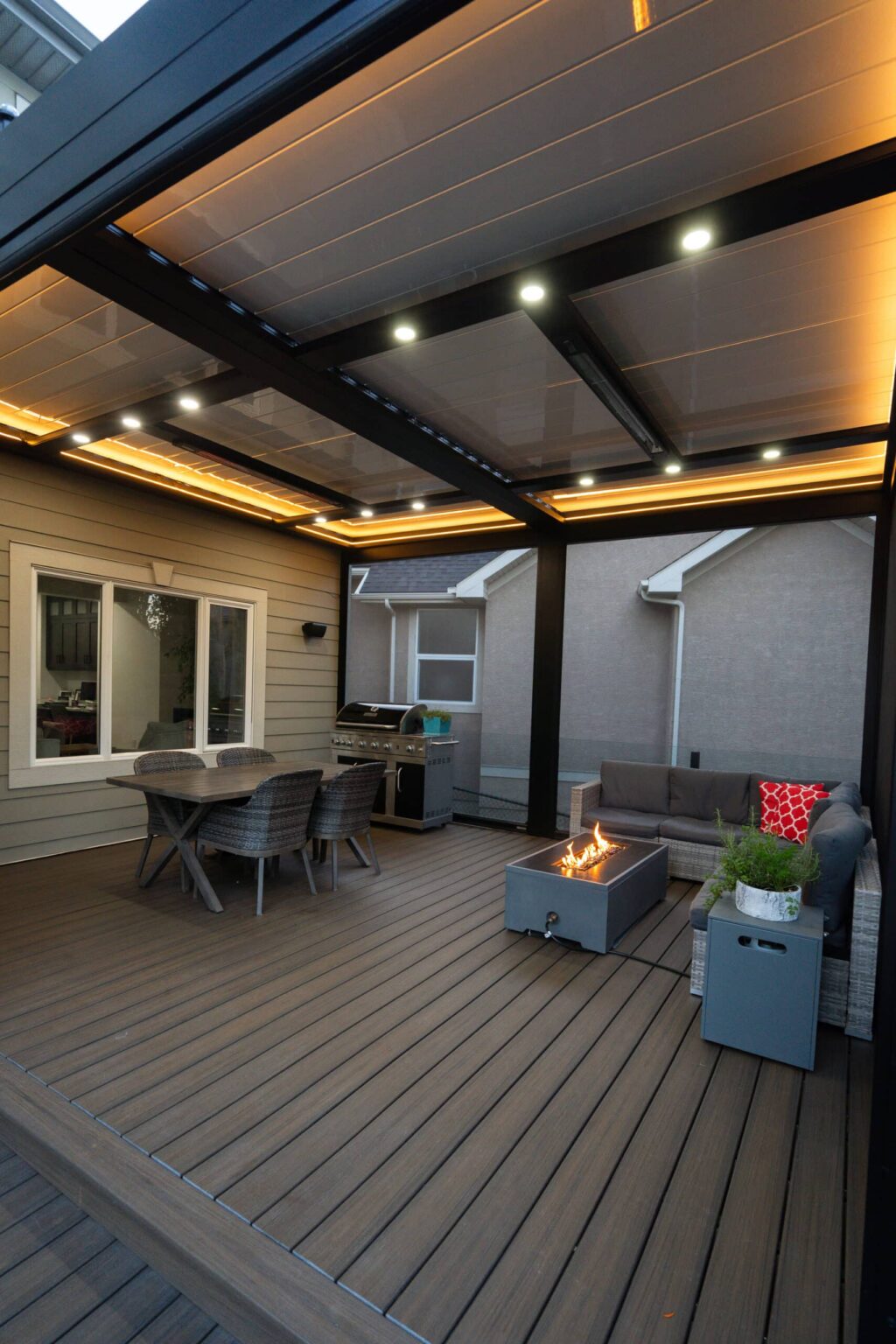 Covered deck lounge with lighting and a fire table