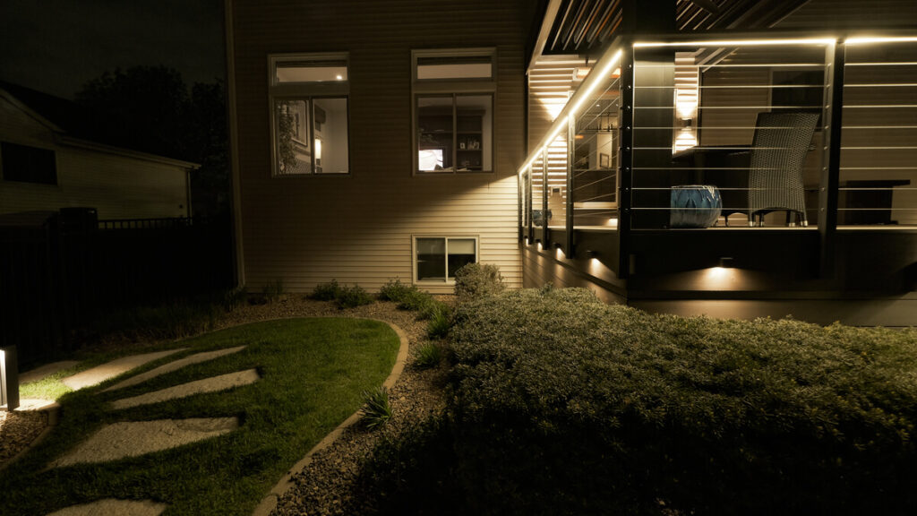 Deck fascia lights and a lit lawn path at night